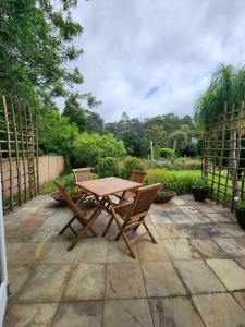 a wooden table and chairs on a patio at Roux Casa in Swellendam +8 photos