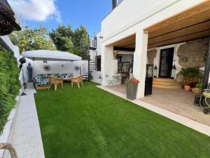 a backyard with green grass and a table and umbrella at Los Ángeles de Sanmartín in Jimena de la Frontera +38 photos