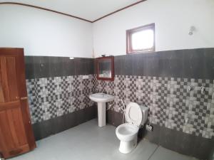 a bathroom with a toilet and a sink at Adithya Resort in Nikawatawana