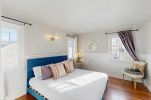 a bedroom with a white bed and two windows at The Jul on State in Bremerton