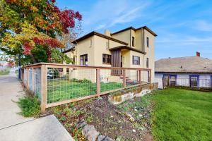 a house with a fence in front of a yard at The Jul on State in Bremerton
