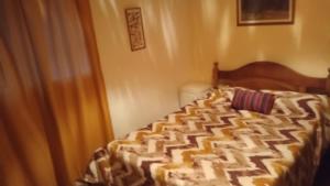 a bedroom with a bed with a comforter on it at Corazonada in Volcán
