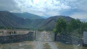 a gate in a stone wall with mountains in the background at Corazonada in Volcán