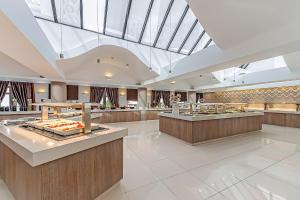 a lobby with a cafeteria with a large skylight at Porto Platanias Beach Resort & Spa in Plataniás