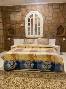 a bedroom with a large bed with a stone wall at Luxor Nile Palace in Luxor