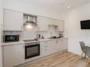 a kitchen with white cabinets and a microwave at Ullswater in Ulverston