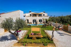 een huis met een tuin met een stoel in de tuin bij Sun Flower Villas in Agia Marina Nea Kydonias