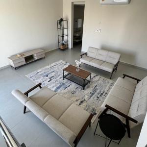 a living room with two couches and a table at Dune View Luxury Villas in Ḩawīyah