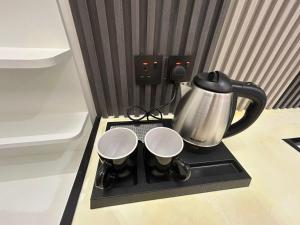 a tea kettle and two cups on a tray at قمرة قباء Cuba moon2 in Al Madinah
