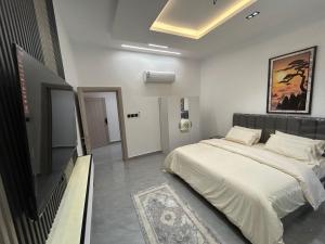 a bedroom with a bed and a flat screen tv at قمرة قباء Cuba moon2 in Al Madinah