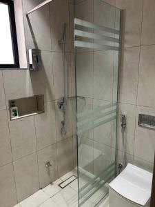 a bathroom with a glass shower with a toilet at قمرة قباء Cuba moon2 in Al Madinah