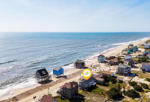 an aerial view of a beach with houses and the ocean at 8077 - Beachin' It in South Rodanthe