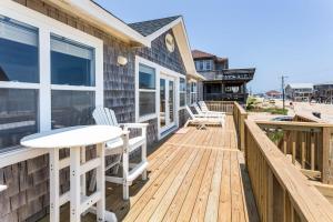 a wooden deck with a table and chairs on it at 8077 - Beachin' It in South Rodanthe