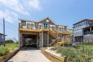 a large house with a wooden staircase leading up to it at 8077 - Beachin' It in South Rodanthe +43 photos