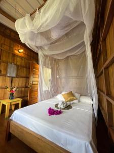 a bedroom with a white bed with a canopy at Cabañas Arrecifes in El Valle