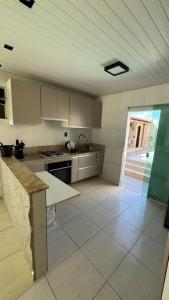 a kitchen with white cabinets and a table in it at Casa aconchegante com piscina e wi-fi rápido in Aracaju