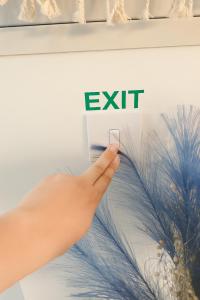 een hand die een mobiele telefoon vasthoudt voor het uitgangsbord bij Central House in Limassol