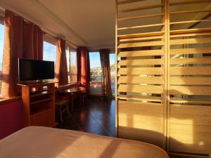 a hotel room with a bed and a television at La Maison Du Coteau in Cachan