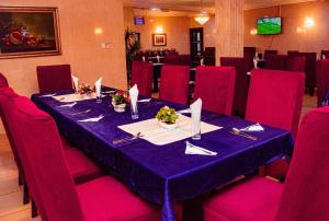 a dining room with a blue table and red chairs at Dees Hotels Apartments And Suites in Lagos