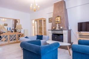 a living room with blue chairs and a fireplace at Trikala Homey Vibes in Tríkala