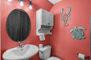 锡格罗夫海滩The Bungalows at Seagrove 114的浴室设有红色的墙壁、水槽和镜子