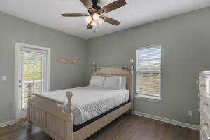 锡格罗夫海滩The Bungalows at Seagrove 114的一间卧室，里面有一张床和一个吊扇 更多13张照片