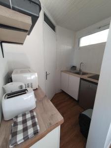 a small kitchen with a sewing machine on a counter at Cozy studio with private garden and separate entrance in Villeneuve-Loubet
