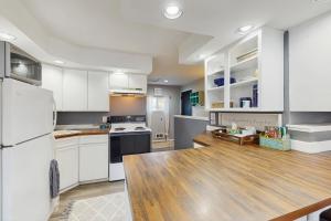 Una cocina con gabinetes blancos y una mesa de madera. en Scandia Suite, en Keyport 4 fotos más