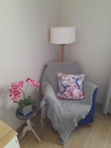 una silla con una almohada y un jarrón de flores en Casa Carla, en Granadilla de Abona