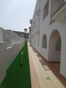 a corridor of a building with green grass at Pegaso II in San Juan de los Terreros