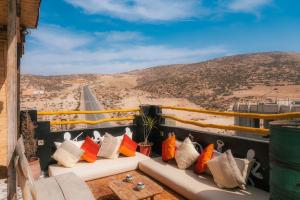 Un balcón con almohadas y vistas al desierto en Light House Imsouane, en Imsouane