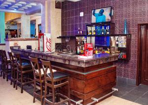 a bar in a restaurant with a counter and chairs at Dees Hotels Apartments And Suites in Lagos