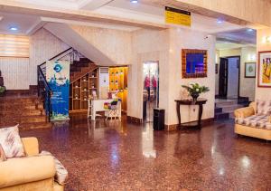 a lobby with couches and a table and a staircase at Dees Hotels Apartments And Suites in Lagos +39 photos