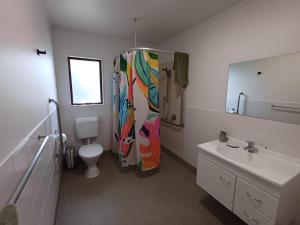 a bathroom with a shower with a colorful shower curtain at House in Restful Setting in Whangarei