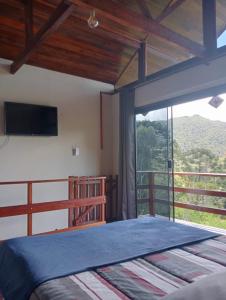 ein Schlafzimmer mit einem Bett und einem großen Fenster in der Unterkunft Sítio Araucária in Itamonte + 16 Fotos