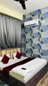 a bedroom with two beds with red pillows at SUNRISE INN hotel in Bikaner