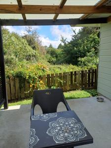 a chair sitting on a patio with a fence at House in Restful Setting in Whangarei