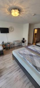 a bedroom with a large bed and a chandelier at Steinhübel Uni-Nähe in Homburg +2 photos