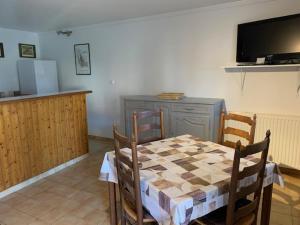 a dining room with a checkered table and chairs and a television at logement dans ferme equestre in Lyons-la-Forêt