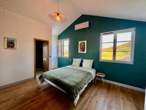 a bedroom with a bed and a green wall at Ferme Ihartzetako in Ascain