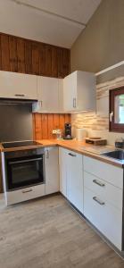 a kitchen with white appliances and wooden cabinets at Chalet du Feignole in Gerbépal +13 photos