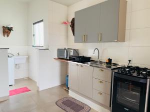 a kitchen with a sink and a stove top oven at Apartamento com Varanda e Ar Condicionado in Sinop