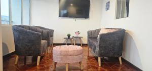 two chairs and a stool in a room with a tv at Aparto hotel del centro in Filandia