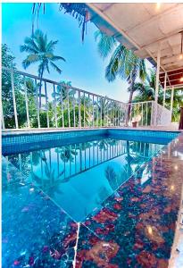 a swimming pool with blue water and palm trees at Beach Touch 4 Bedroom Modern Villa with Plunge pool by "Dreme 100 BnB" in Morjim
