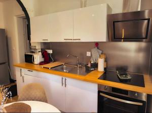 a kitchen with white cabinets and a sink and a microwave at Villa Leone Rénové à 500m de la Plage in Dunkerque +22 photos