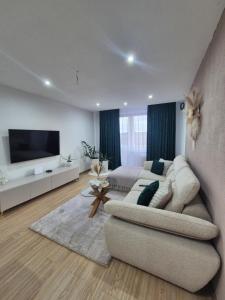 a living room with a couch and a flat screen tv at Apartmán LUX Lučenec in Lučenec