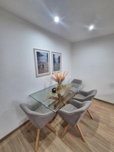 a dining room with a glass table and chairs at Apartmán LUX Lučenec in Lučenec