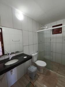 a bathroom with a toilet and a sink and a mirror at Pousada Villa Zarah in São Miguel do Gostoso +34 photos