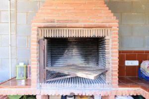 a brick fireplace with a wooden bench in it at Casa Rural Mas ROTAVELLA in Montbrió del Camp