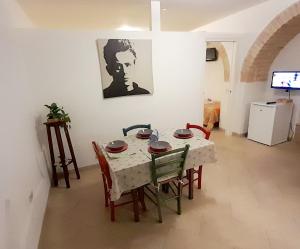 アルベロベッロにあるNonna Livia - vicino centro storico Trulliのテーブルと椅子とテレビのあるダイニングルーム +5枚の写真